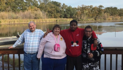 La Cruz clients standing together on a creek bridge smiling and enjoying the afternoon.
